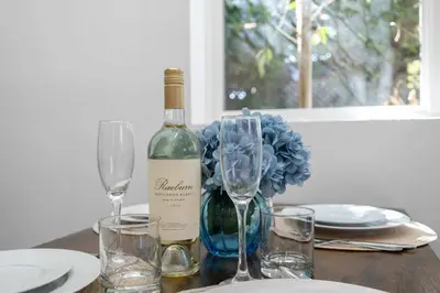 a bottle of wine sitting on a table with glasses at New Listing Iconic Venice Living by Colby & Conrad in Los Angeles