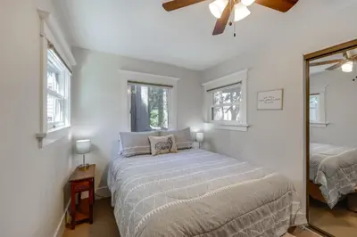 a bedroom with a bed and a mirror at Walk to Lake Arrowhead Village Bright Gem with Deck in Lake Arrowhead
