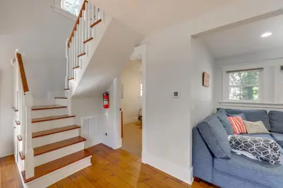 a living room with a blue couch and stairs at Walk to Lake Arrowhead Village Bright Gem with Deck in Lake Arrowhead