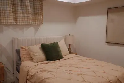 a bedroom with a bed with green and white pillows at The Sunset Gathering in Los Angeles
