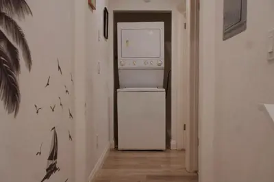 a kitchen with a white refrigerator in a hallway at The Sunset Gathering in Los Angeles