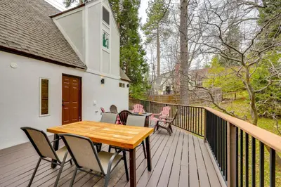 a wooden deck with a wooden table and chairs at 1 Mi to Lake Arrowhead! All-Season Family Getaway in Lake Arrowhead