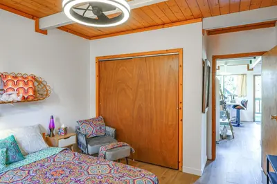 a bedroom with a bed and a chair and a door at Mtn Views Near Hiking Pine Mountain Club Getaway! in Pine Mountain Club
