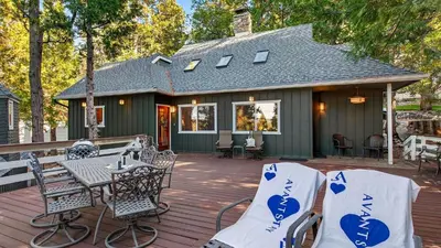a patio with a table and chairs on a house at Holiday Lake Cabin by AvantStay Large Deck Cozy Fireplace Near Arrowhead Village in Lake Arrowhead