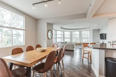 a kitchen and dining room with a wooden table and chairs at 3BR 2BTH Santa Monica Apartment - Pool, Balcony, Near LAX in Los Angeles