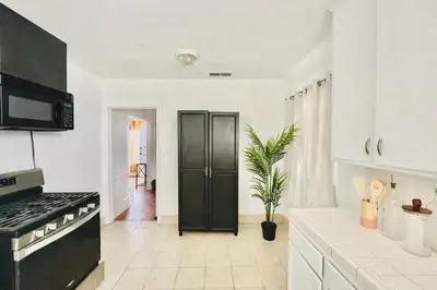 a kitchen with white cabinets and a black refrigerator at Spacious 3BR House Culver City Santa Monica & West LA in Los Angeles
