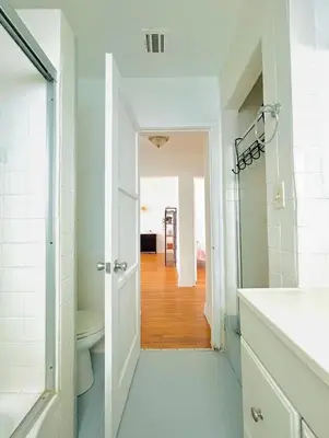 a white bathroom with a toilet and a hallway at Spacious 3BR House Culver City Santa Monica & West LA in Los Angeles