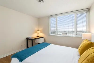 a bedroom with a bed and a desk and a window at Golden Hour Glow - Stunning 3BR Overlooking the Marina in Los Angeles