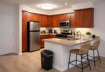 a kitchen with wooden cabinets and a stainless steel refrigerator at Marina 1-Bedroom & 2-Bedroom - Near Venice Beach & Marina in Los Angeles