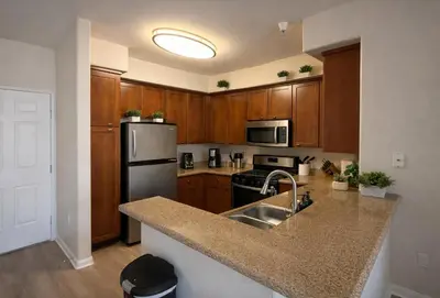 a kitchen with wooden cabinets and a stainless steel refrigerator at Marina del Rey Luxury 2BR 2BA - Close to Venice Beach in Los Angeles