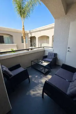 a balcony with couches and a table and a palm tree at Marina del Rey 2BR-2BA Oasis Near Venice Beach Boardwalk in Los Angeles