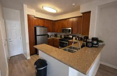 a kitchen with wooden cabinets and a granite counter top at Marina del Rey Modern 2BR - Venice in Los Angeles