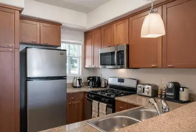 a kitchen with wooden cabinets and a stainless steel refrigerator at Marina del Rey Cozy 1BR - Near Venice Beach in Los Angeles