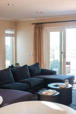 a living room with a blue couch and tables at Beautiful Monterey Park Home With a View, Backyard and BBQ in Monterey Park