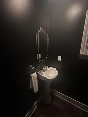 a black bathroom with a sink and a mirror at Altadena Retreat Near Rose Bowl and Pasadena in Altadena