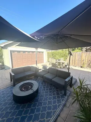 a patio with a couch and an umbrella at Altadena Retreat Near Rose Bowl and Pasadena in Altadena
