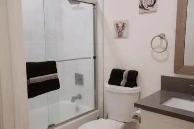 a bathroom with a shower and a toilet and a sink at Noir and Gold Retreat in Los Angeles