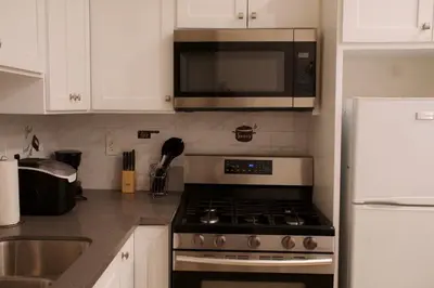 a kitchen with a stove and a microwave at Noir and Gold Retreat in Los Angeles