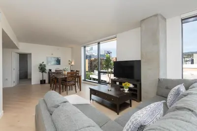 a living room with a couch and a table at 2Bed Apt View of Hollywood Sign & Rooftop Pool in Los Angeles