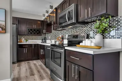 a kitchen with dark wood cabinets and a stove at Marina Chic Apartment! Free Parking in Los Angeles