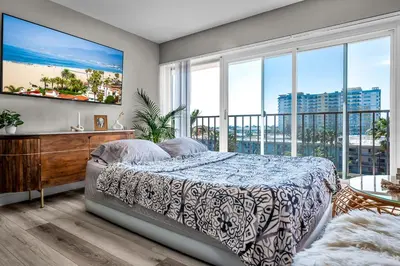 a bedroom with a bed and a large window at Marina Chic Apartment! Free Parking in Los Angeles