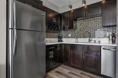 a kitchen with wooden cabinets and a stainless steel refrigerator at Marina Chic Apartment! Free Parking in Los Angeles