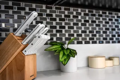 two plastic knives in a knife block next to a plant at Marina Chic Apartment! Free Parking in Los Angeles