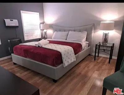 a bedroom with a large bed with a red blanket at Residents inn in Los Angeles