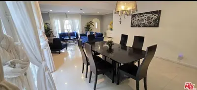 a dining room and living room with a table and chairs at Residents inn in Los Angeles