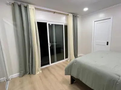 a bedroom with a bed and a large window at Modern Family 3BR Near LAX & Disney in Torrance