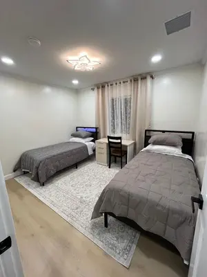 a bedroom with two beds and a table and a chair at Modern Family 3BR Near LAX & Disney in Torrance