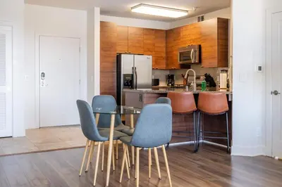 a kitchen with a table and chairs and a refrigerator at Sleek Marina Den, Central, Gym, Pool, King Bed in Los Angeles