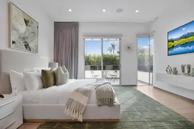 a white bedroom with a large bed and a balcony at Colgate Vantage in Los Angeles