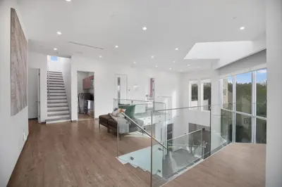 a living room with a glass staircase in a house at Colgate Vantage in Los Angeles
