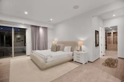 a white bedroom with a bed and a night stand at Colgate Vantage in Los Angeles