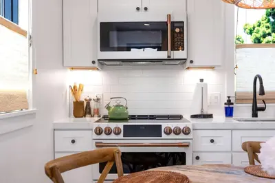 a kitchen with a stove and a microwave at NEW Venice Rose Ave Retreat with Sunset Deck in Los Angeles