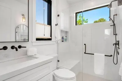 a white bathroom with a shower and a toilet at NEW Venice Rose Ave Retreat with Sunset Deck in Los Angeles