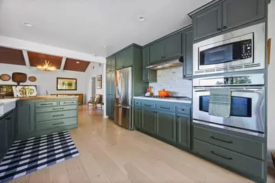 a kitchen with green cabinets and stainless steel appliances at Luxury Ojai Escape Pool, Jacuzzi & Tennis Court in Ojai