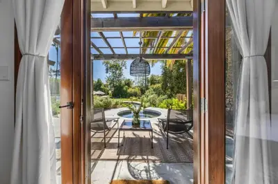 an open door to a patio with a table and chairs at Luxury Ojai Escape Pool, Jacuzzi & Tennis Court in Ojai