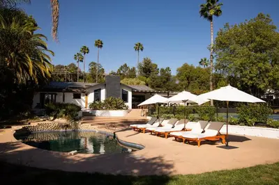 a group of chairs and umbrellas next to a pool at Luxury Ojai Escape Pool, Jacuzzi & Tennis Court in Ojai