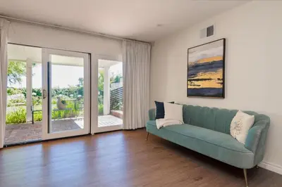a living room with a green couch and sliding glass doors at Sunset villa in Los Angeles