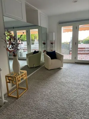 a living room with two chairs and a table with a vase at Sunset villa in Los Angeles