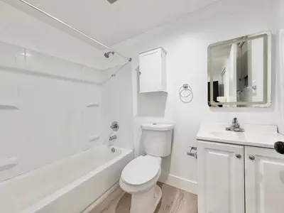 a white bathroom with a toilet and a sink at 1622 Palm Terrace in Los Angeles