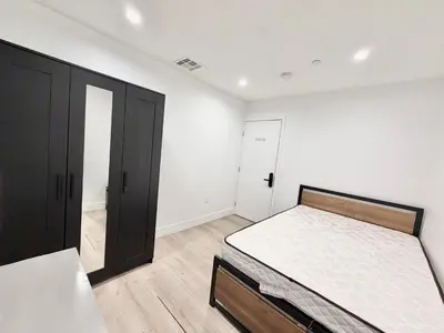 a white bedroom with a bed and a closet at 1622 Palm Terrace in Los Angeles