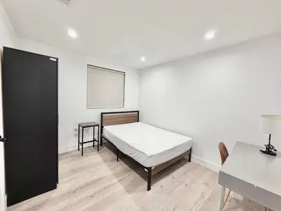 a bedroom with a bed and a white wall at 1622 Palm Terrace in Los Angeles