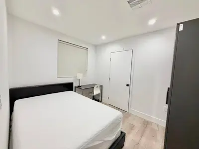 a white bedroom with a bed and a mirror at 1622 Palm Terrace in Los Angeles