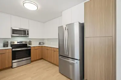 a stainless steel refrigerator in a kitchen with wooden cabinets at Drift & Dream - Opulent 1BR Marina Escape in Los Angeles