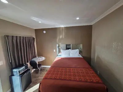 a hotel room with a bed and a desk at Astro Motel in Los Angeles