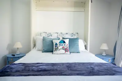 a bedroom with a white bed with two blue tables at Beach House by LA Coast in Torrance