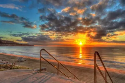 a sunset over the ocean with a sandy beach at Beach House by LA Coast in Torrance